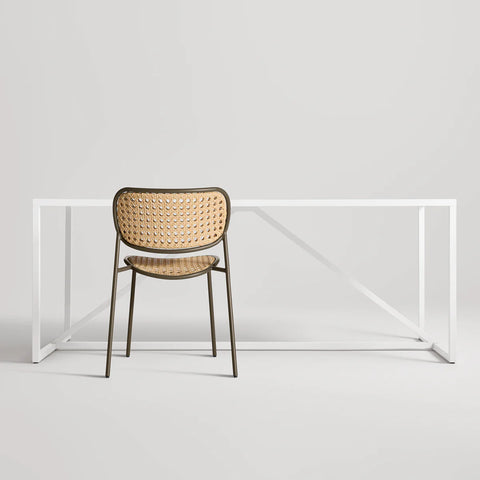 Made You Look Outdoor Chair by Blu Dot in Dark Olive with plastic rattan seat and back, rear view with dining table