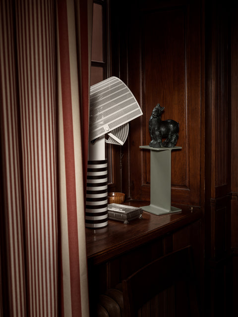 Museum Pedestal by String Furniture in green displaying a dark horse sculpture on a wood panelled desk
