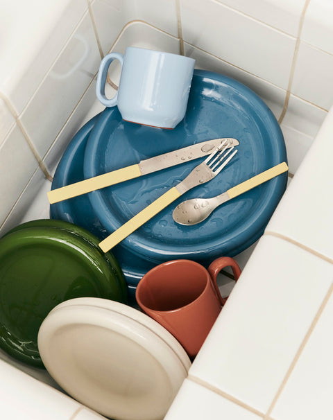 HAY Barro Cups, Natural, terracotta cups, a natural cup and a light blue cup stacked with blue and green plates in a tiled sink