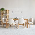 Four Gus Modern Malloy dining chairs in cream fabric around oak dining table in modern Canadian home interior