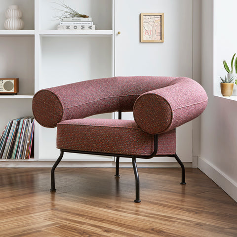 Gus Modern Mirador lounge chair in burgundy speckled fabric positioned in modern living room with white shelving and hardwood floors