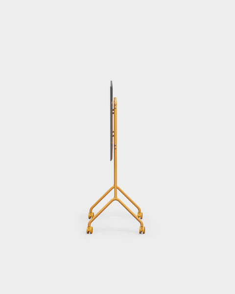 Pedestal Moon Light TV Stand in Apricot, compact steel TV stand on wheels, seen edge on without a screen fitted