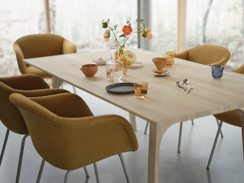 Earnest Extendable Table by Muuto in oak set for guests, with Fiber Soft Armchairs and Raise Carafe and Glasses