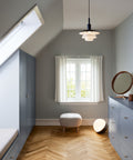 scandinavian inspired room with blue cabinetry and herringbone flooring with ball floor lamp