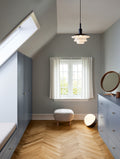 scandinavian inspired room with blue cabinetry and herringbone flooring with ball floor lamp