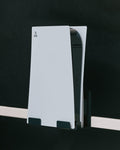 Pedestal PS5 Mount holding a white PlayStation 5 upright on a stand bar against a dark background