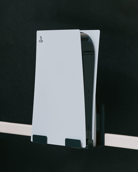 Pedestal PS5 Mount holding a white PlayStation 5 upright on a stand bar against a dark background