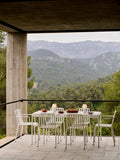 HAY Barro Oval Dish, Large, Off-White, glazed terracotta oval serving dish, table laid on a concrete terrace overlooking wooded mountains
