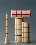 HAY Column Candle, Medium, Off-White, Bordeaux, Blue and Silver, stearin pillar candles, one laid on its side on a grey blue backdrop
