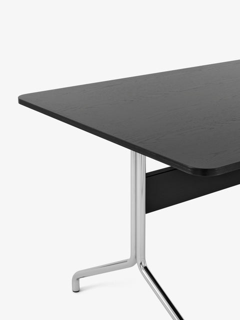 Detail view of AV24 Dining Table by &Tradition in black oak with chrome base highlighting slim tabletop and sculptural metal frame