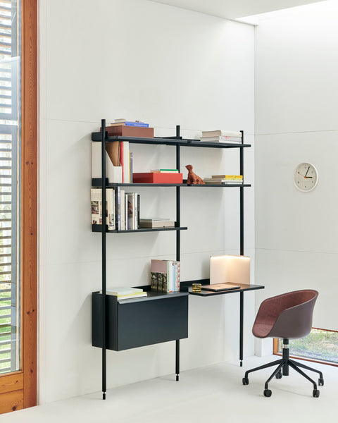 HAY Wall Clock, White, recycled ABS wall clock, on a white wall beside black wall shelving, a desk and a red brown office chair