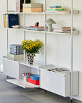 HAY Jessica Hans Shadow Vase, Black and White, patterned ceramic vase with a ruffled rim, holding yellow flowers on white shelving with books