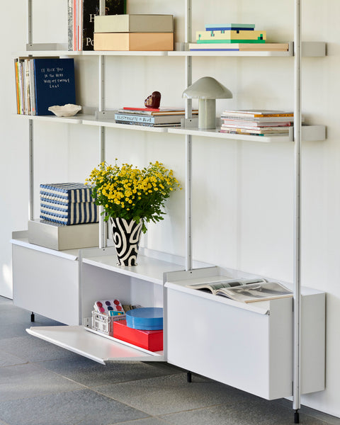 HAY Jessica Hans Shadow Vase, Black and White, patterned ceramic vase with a ruffled rim, holding yellow flowers on white shelving with books