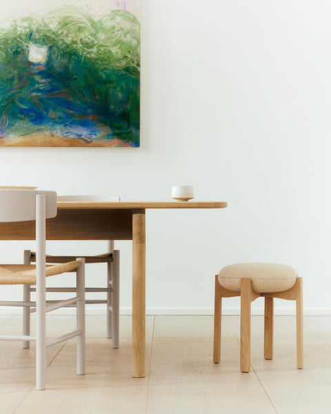 scandinavian dining room with stool and abstract artwork