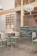 Fredericia Plan Chairs with green frame and grey upholstery in restaurant interior with marble bar
