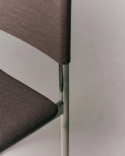 Close-up detail of Fredericia Plan Chair backrest and seat in dark fabric with brushed chrome legs
