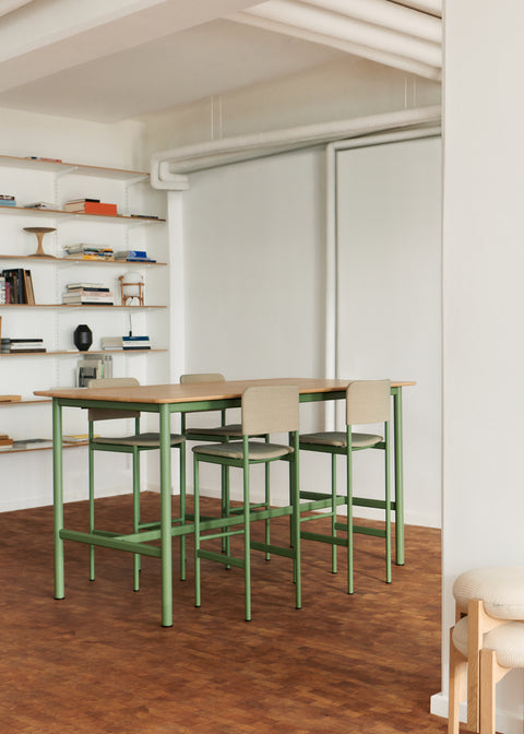 PLAN Barstools in oak and black finish styled in a light-filled café with high tables.