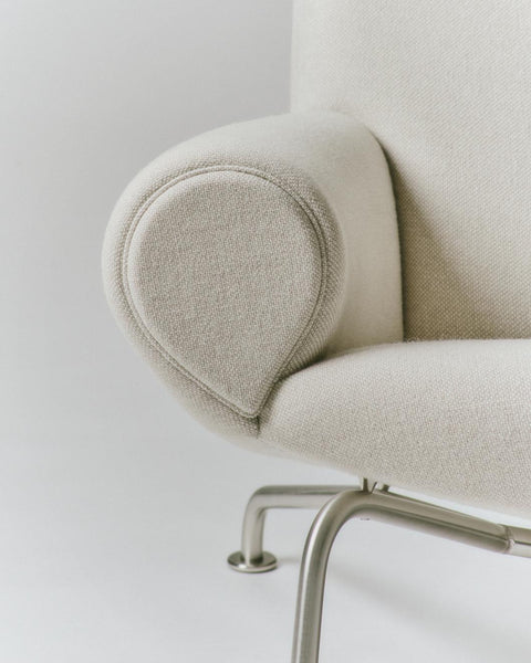 Close up of Wegner Queen Chair armrest rounded roll arm in Hallingdal wool on brushed steel frame