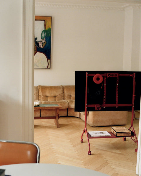 Pedestal Remote Box Mount in Burnin' Red, fitted to a red Pedestal stand seen from behind in a living room