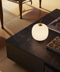 vl45 white opal portable lamp on a coffee table from Louis Poulsen