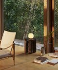 scandinavian interior with lounge chair and portable table lamp by Louis Poulsen