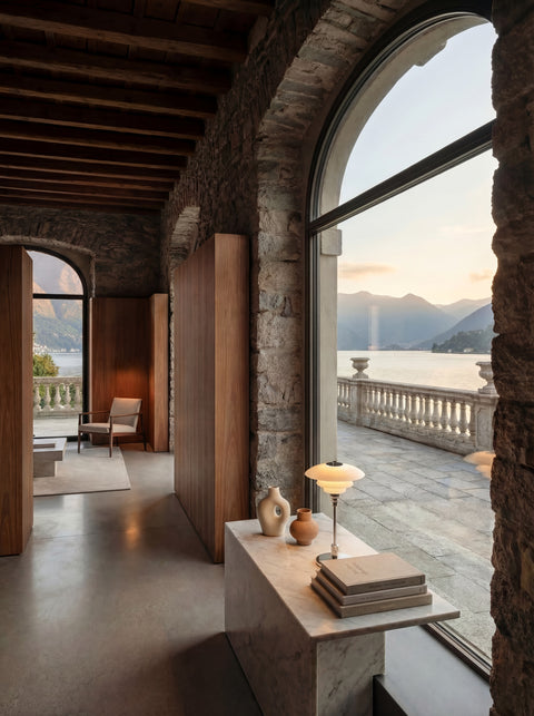 Louis Poulsen PH 1/1 Portable lamp in chrome on a marble console in a stone villa overlooking a lake