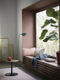 Muuto Leaf Floor Lamp illuminating a bright bedroom with minimalist furniture.