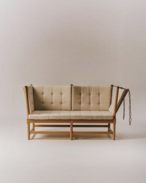 Studio front view of Fredericia Spokeback Sofa in natural linen with oak light oil frame and adjustable ends