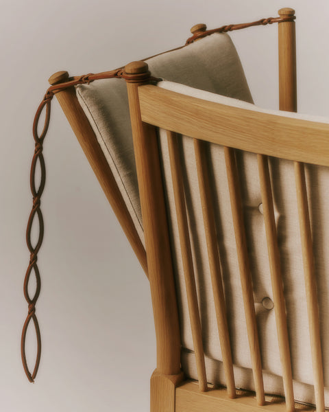 Leather strap detail on adjustable spoke back and oak post of the Fredericia Spokeback Sofa with natural linen cushions designed by Borge Mogensen