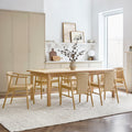 Gus* Modern Strand Dining Chair in Royal Oak with upholstered fabric at round dining table with white shelving and cork pendant lights