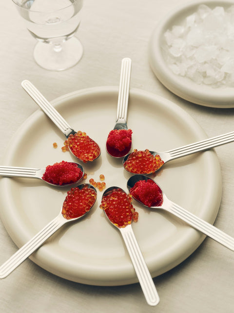 HAY Barro Plates, Ø24, Off-White, glazed terracotta plate, seen from above with spoons of red caviar arranged in a circle