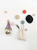 Muuto Dots wood wall hooks in various sizes on wall, versatile design for home organization and modern decor.