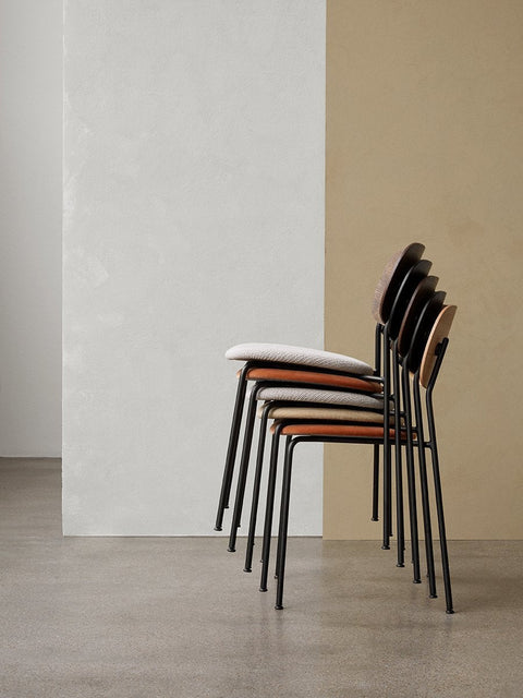 Audo Copenhagen Co Dining Chair, Non-Upholstered, side view of five Co Dining Chairs stacked in various upholstery and wood veneer finishes against a two-tone wall