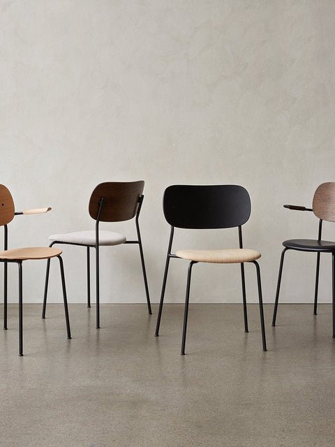 Audo Copenhagen Co Dining Chair, Non-Upholstered, row of four Co Dining Chairs with black steel frames, showcasing various oak veneer and upholstered finishes