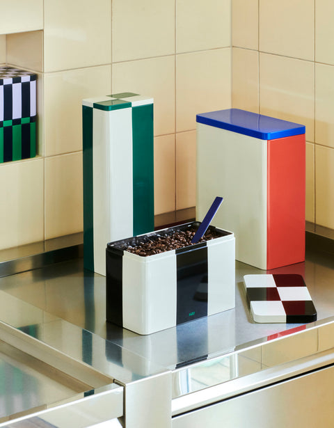 HAY Tin Container, X-Large, Off-White, Blue and Red, tinplate storage tin on a steel counter beside a green tin and a black tin of coffee beans