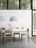 oak dining chairs and white table by muuto