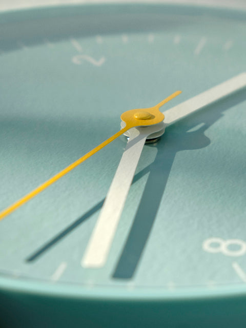 HAY Wall Clock, Blue, recycled ABS wall clock, macro detail crop of the centre hub, white hands and yellow second hand