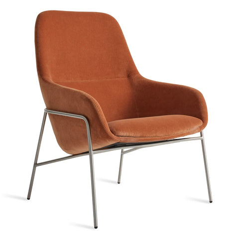 Blu Dot Acre Lounge Chair in burnt orange velvet with brushed steel legs, three-quarter front view on white background