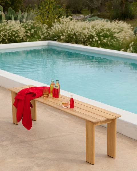 Muuto Assemble Bench teak outdoor bench beside swimming pool with beverages on seat