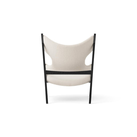 Rear view of the Knitting Lounge Chair in cream upholstery with black oak frame by Audo Copenhagen.