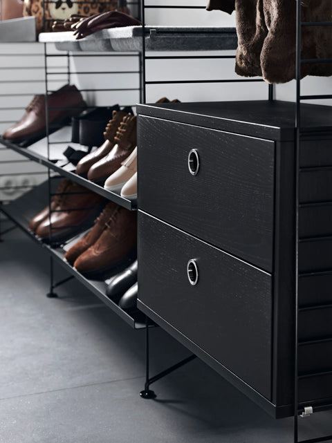 Black String® System shoe shelves with modular drawers, styled with leather shoes and outerwear in a modern entryway