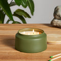 Lost in the Mild Outdoor Candle by Blu Dot, large size in Olive ceramic vessel, lit outdoors on teak surface