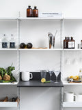 Scandinavian kitchen setup with String® System including shelves, bar accessories, and hanger rack