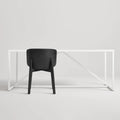 Blu Dot Buddy Chair in black on ash rear view styled with a white Strut dining table on white background