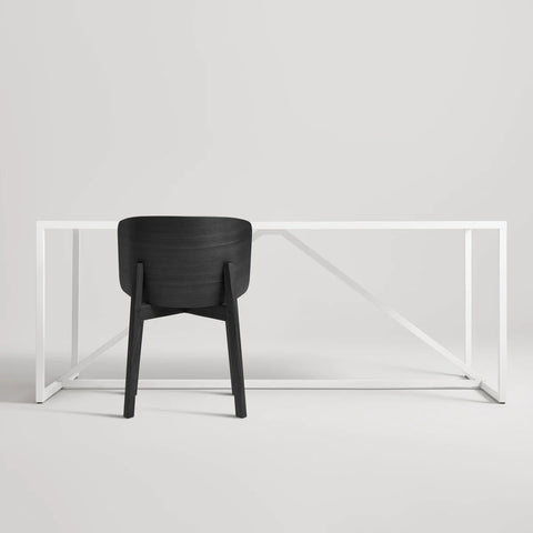 Blu Dot Buddy Chair in black on ash rear view styled with a white Strut dining table on white background