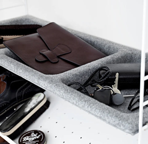 Light grey felt String® Bowl Shelf used for organizing everyday essentials like keys, wallet, and accessories within modular shelving system