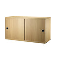 String Furniture cabinet with sliding doors in oak – modern Scandinavian shelving component