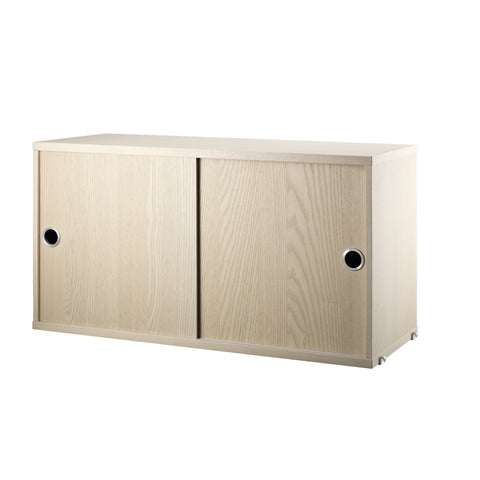 String Furniture cabinet with sliding doors in ash – minimalist Scandinavian storage design