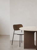 Audo Copenhagen Co Dining Chair, Without Arms, Partially Upholstered, Co Dining Chair with dark wood back, grey upholstered seat, and black frame next to a round table with a stone top