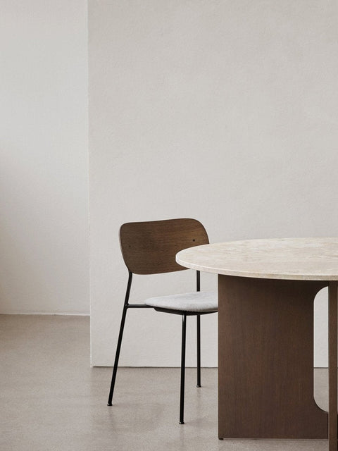 Audo Copenhagen Co Dining Chair, Without Arms, Partially Upholstered, Co Dining Chair with dark wood back, grey upholstered seat, and black frame next to a round table with a stone top